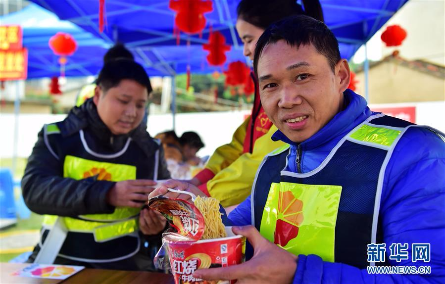 1月18日,来自江西瑞金市黄柏乡的钟艳华(前)在中国石油漳州龙江路