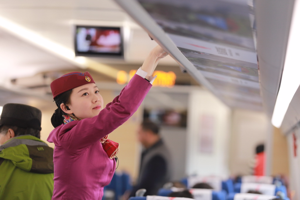 图为2017年02月09日，重庆，列车员吴丹整理行李架。