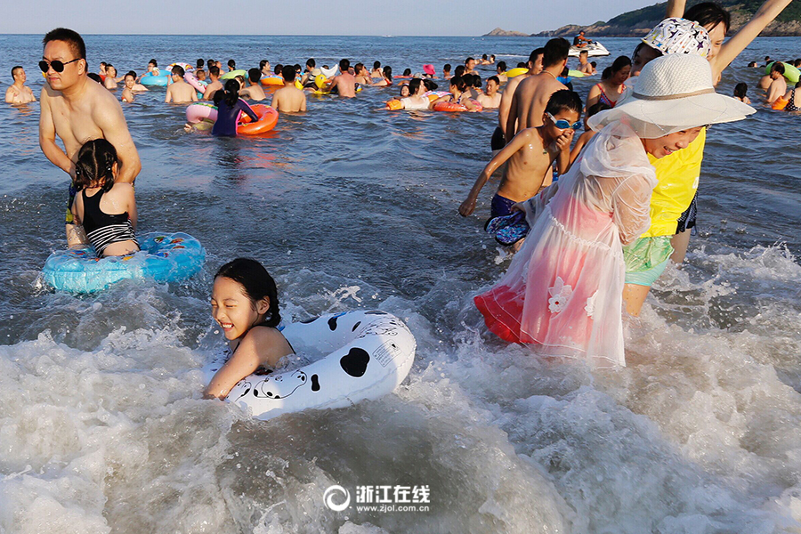 浙江在线7月27日讯(记者 于诗奇 摄)受副高控制,浙江的高温热浪仍在持续。酷热难耐,不少人选择到海边游泳消暑纳凉。7月26日,舟山东沙湾海滨浴场人头攒动,大批游客及市民到这里享受大海的清凉, 场面如同下饺子般热闹。 据浙江气象部门消息,近期内我省仍以晴热高温天气为主。预计今天、明天的最高温度:沿海地区35-37,其它地区37-39,局部可达40。注意做好防暑降温工作。